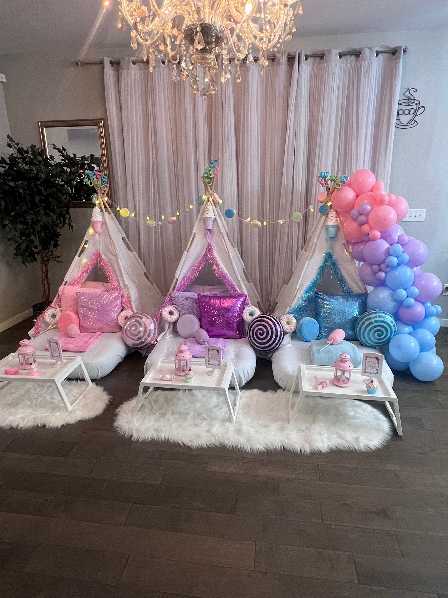 Wide-angle view of a Candy Land-themed luxury sleepover setup with pastel balloons, colorful pillows, and candy-inspired decorations for a kids' slumber party in Denver.