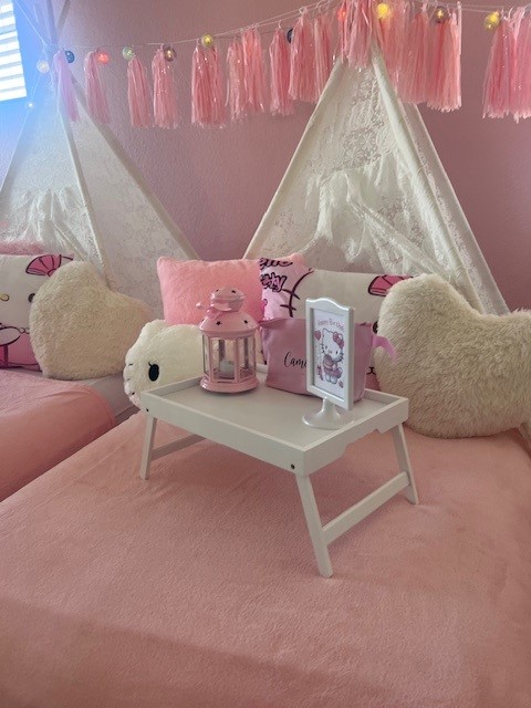 A luxury Hello Kitty-themed sleepover setup featuring adorable pink and white teepees, plush Hello Kitty pillows, and cozy blankets. The scene is accented with string lights, pastel decor, and a playful Hello Kitty backdrop, creating the perfect Instagrammable slumber party for kids